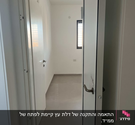 דלת פתוחה מובילה לחדר ריק עם חלון קטן